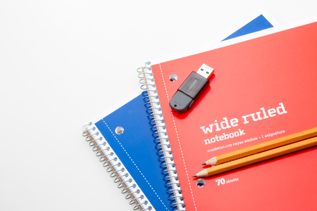 Two notebooks with pencils and usb flash drive.の写真素材