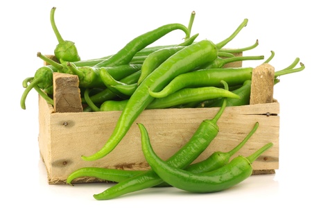 Freshly harvested jalapeno peppers in a wooden crate on a white background の写真素材