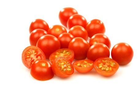 fresh whole and sliced cherry tomatoes on a white background の写真素材