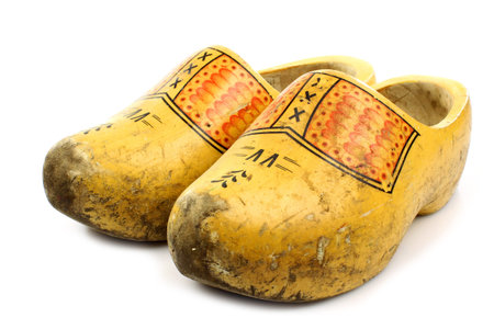 pair of traditional Dutch yellow wooden shoes on a white background 