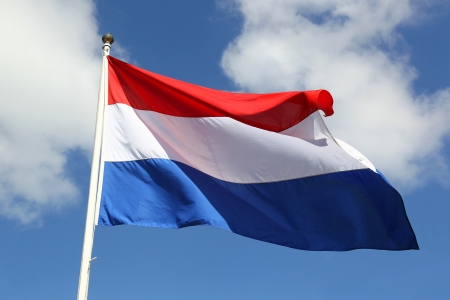 Dutch national flag on liberty day against blue sky with clouds の写真素材