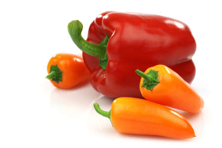 a fresh red and some orange peppers  capsicum on a white background の写真素材