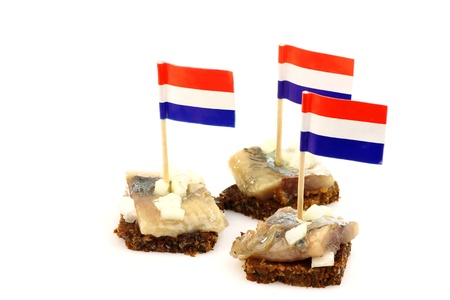 Fresh herring  Dutch  Hollandse Nieuwe   with chopped onions on rye bread on a white background の写真素材