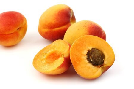 fresh colorful apricots an two halves on a white background の写真素材