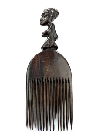 old wooden comb decorated with african figure on a white background の写真素材