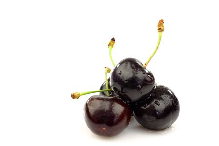 bunch of fresh black sweet cherries on a white background の写真素材