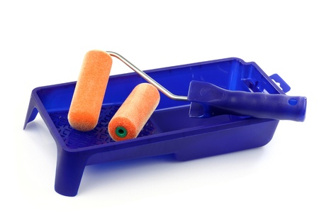 blue plastic paint pan and some paint rollers on a white background の写真素材