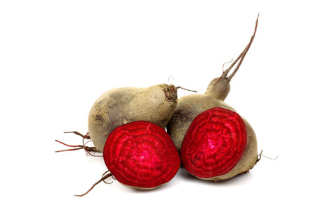 three freshly harvested beetroots and two halves on a white background 