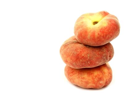stack of fresh colorful flat peaches  donut peaches  on a white background の写真素材