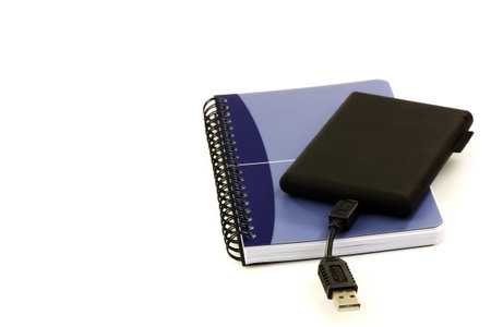 old fashioned notebook and an external hard drive, old and new, on a white background 