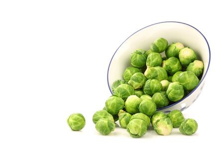 Brussel sprouts coming from a decorated bowl on a white background の写真素材