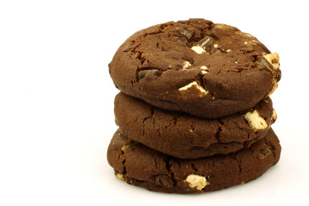 stacked chocolate chip cookies with nuts on a white background 