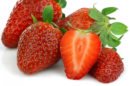 fresh strawberries and a cut one on a white background の写真素材