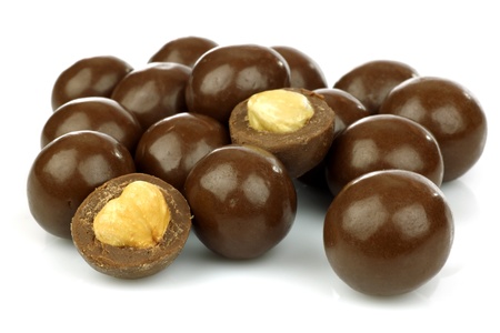 chocolate balls filled with hazelnuts on a white background の写真素材