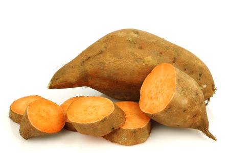 one whole sweet potato and a cut one on a white background