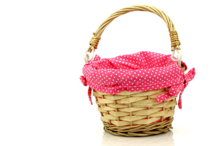 empty wicker basket with pink cloth on a white background の写真素材