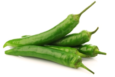 bunch of fresh green chili peppers on a white background の写真素材