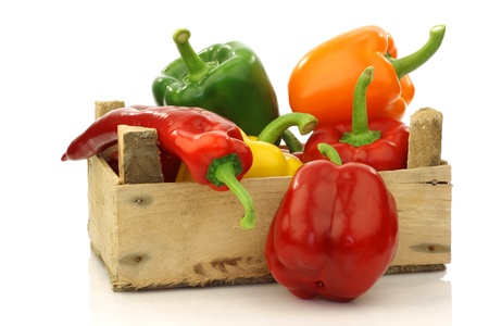 colorful mix of paprika s capsicum  in a wooden box on a white background の写真素材