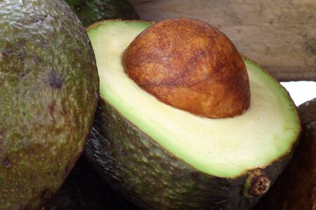 fresh and ripe cut avocado in a wooden crate の写真素材