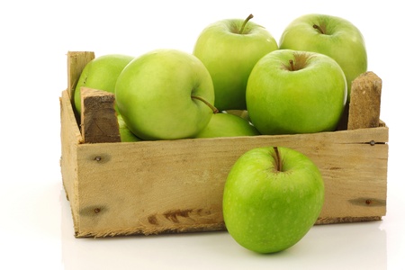 freshly harvested  Granny Smith  apples in a wooden crate on a white background の写真素材