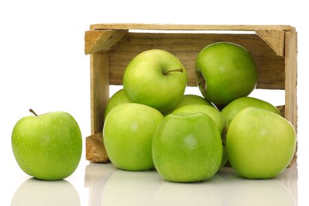 freshly harvested  Granny Smith  apples in a wooden crate on a white background の写真素材