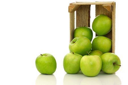 freshly harvested  Granny Smith  apples in a wooden crate on a white background の写真素材