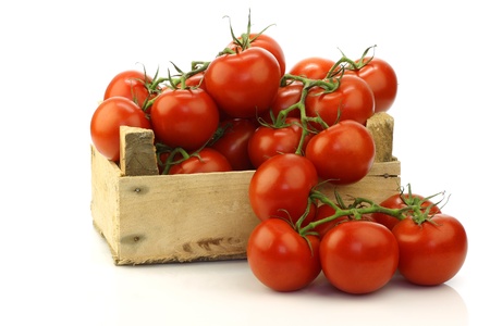 fresh tomatoes in a wooden crate on a white background の写真素材