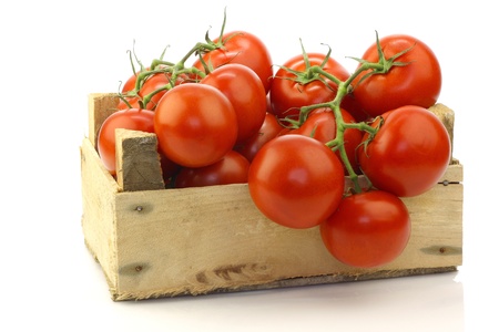 fresh tomatoes in a wooden crate on a white background の写真素材