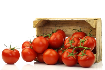 fresh tomatoes in a wooden crate on a white background の写真素材