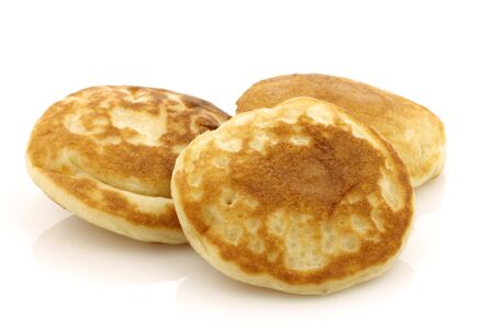 freshly baked traditional Dutch mini pancakes called  poffertjes on a white background の写真素材
