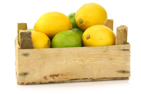 fresh lemons and lime fruits in a wooden box on a white background の写真素材