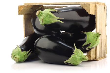 fresh aubergines in a wooden crate on a white background の写真素材