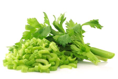 fresh celery and some cut pieces on a white background の写真素材