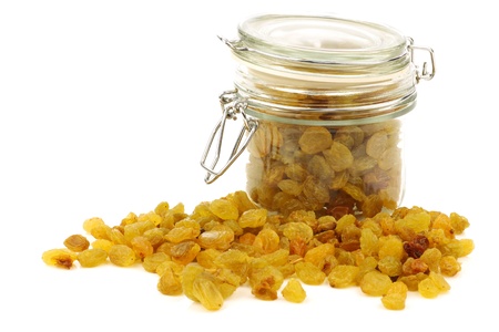dried white raisins in a glass jar on a white background の写真素材