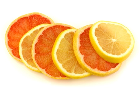 yellow and red grapefruit slices on a white background の写真素材