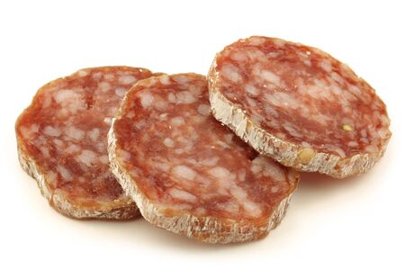 spicy Italian salami sausage slices on a white background の写真素材