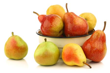 Assortment of different colorful pears in an enamel bowl on a white background の写真素材