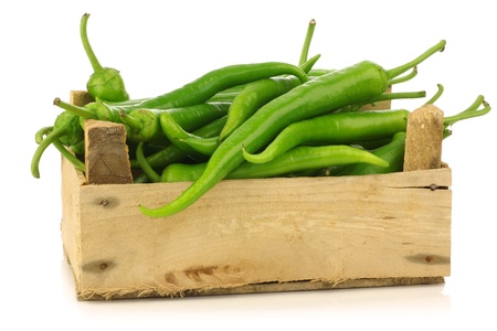 Freshly harvested jalapeno peppers in a wooden crate on a white background の写真素材