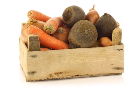 variety of root vegetables in a wooden crate on a white background の写真素材
