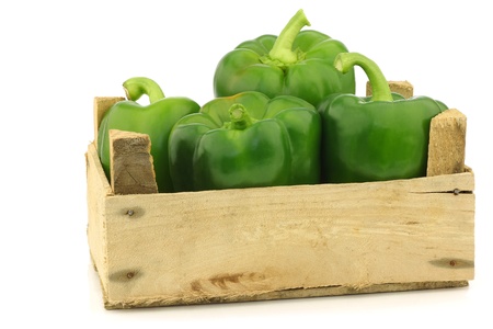 fresh green bell peppers  capsicum  in a wooden crate on a white background の写真素材