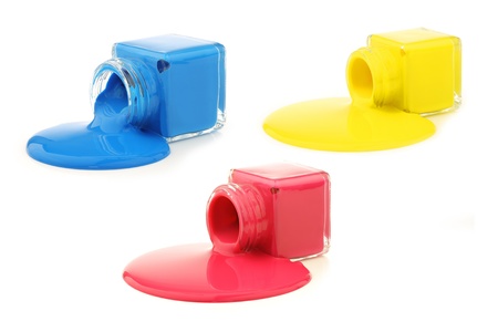 Three bottles with the primary colors spilling paint  on a white backgroundの写真素材