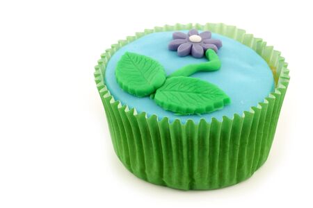 homemade cupcake with a colorful flower on a white background の写真素材