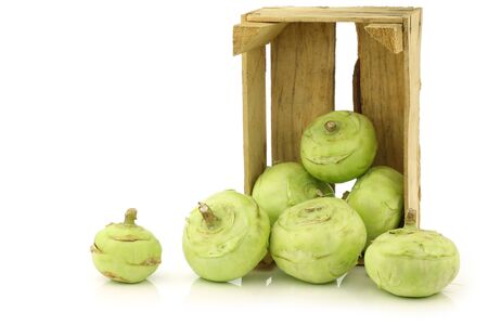 Freshly harvested kohlrabi in a wooden crate on a white background の写真素材