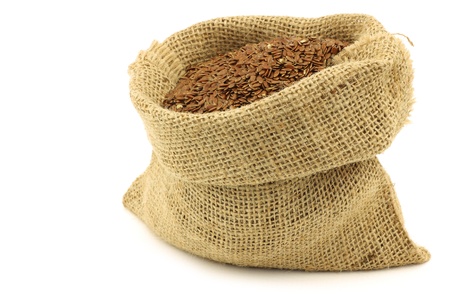 Flax seed  linseed  in a burlap bag on a white background の写真素材