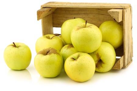 fresh  Golden Delicious  apples in a wooden crate  on a white backgroundの写真素材