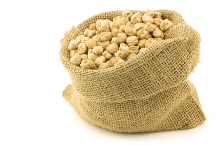 dried chick peas in a burlap bag on a white backgroundの写真素材
