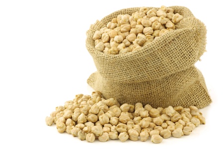 dried chick peas in a burlap bag on a white backgroundの写真素材