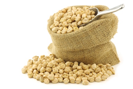 dried chick peas in a burlap bag with an aluminum scoop on a white backgroundの写真素材