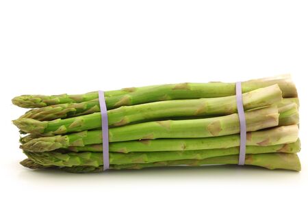  fresh asparagus shoots in a bundle on a white backgroundの写真素材