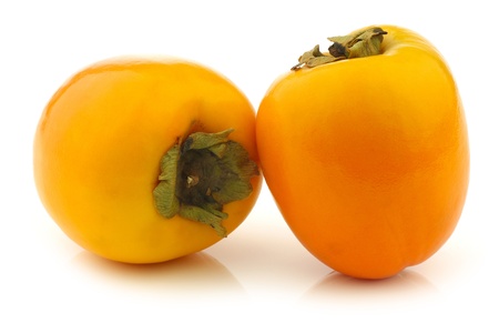 two fresh kaki fruits on a white backgroundの写真素材